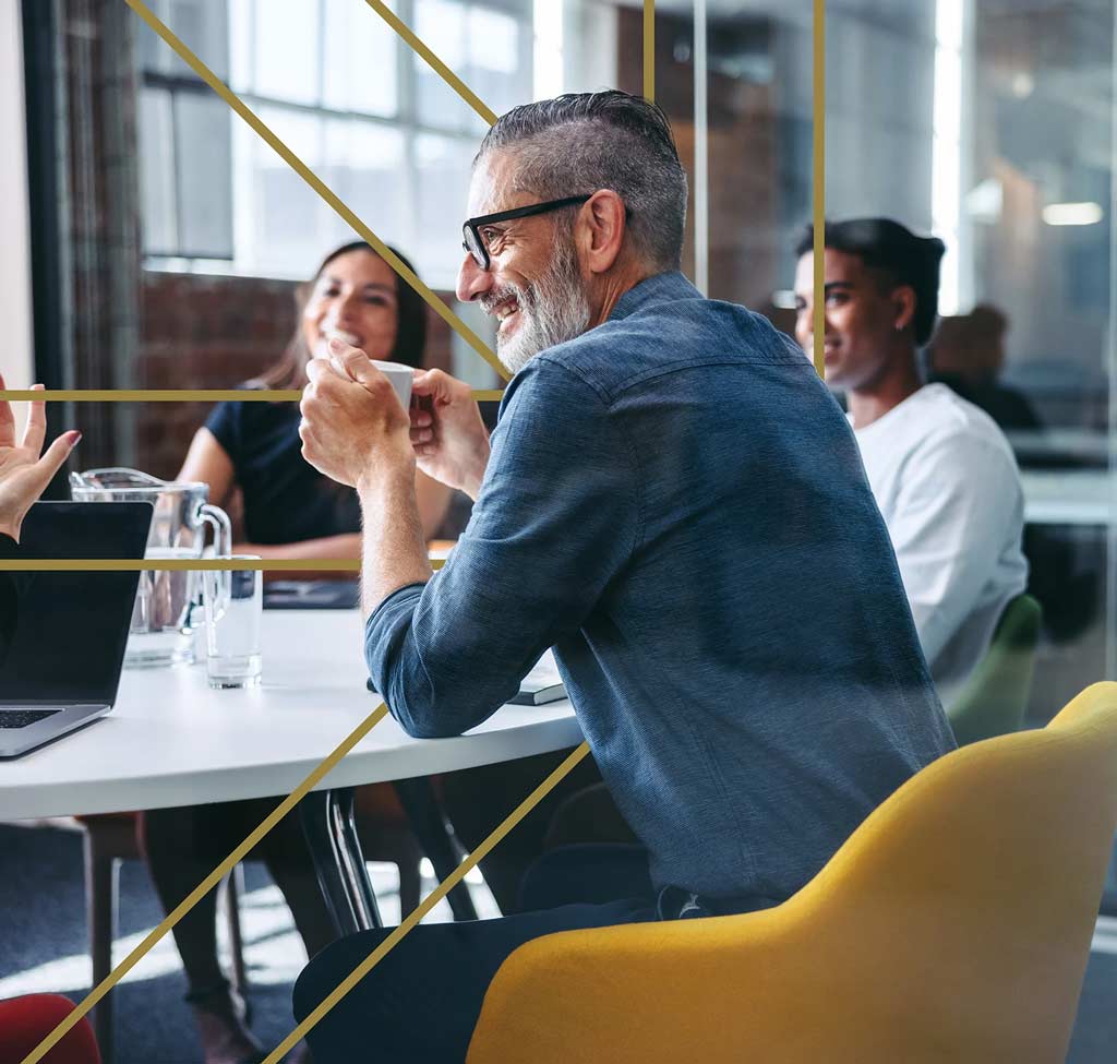 Man sitting in a chair at a table with other people - Pavion Fire Safety, Integration, and Security